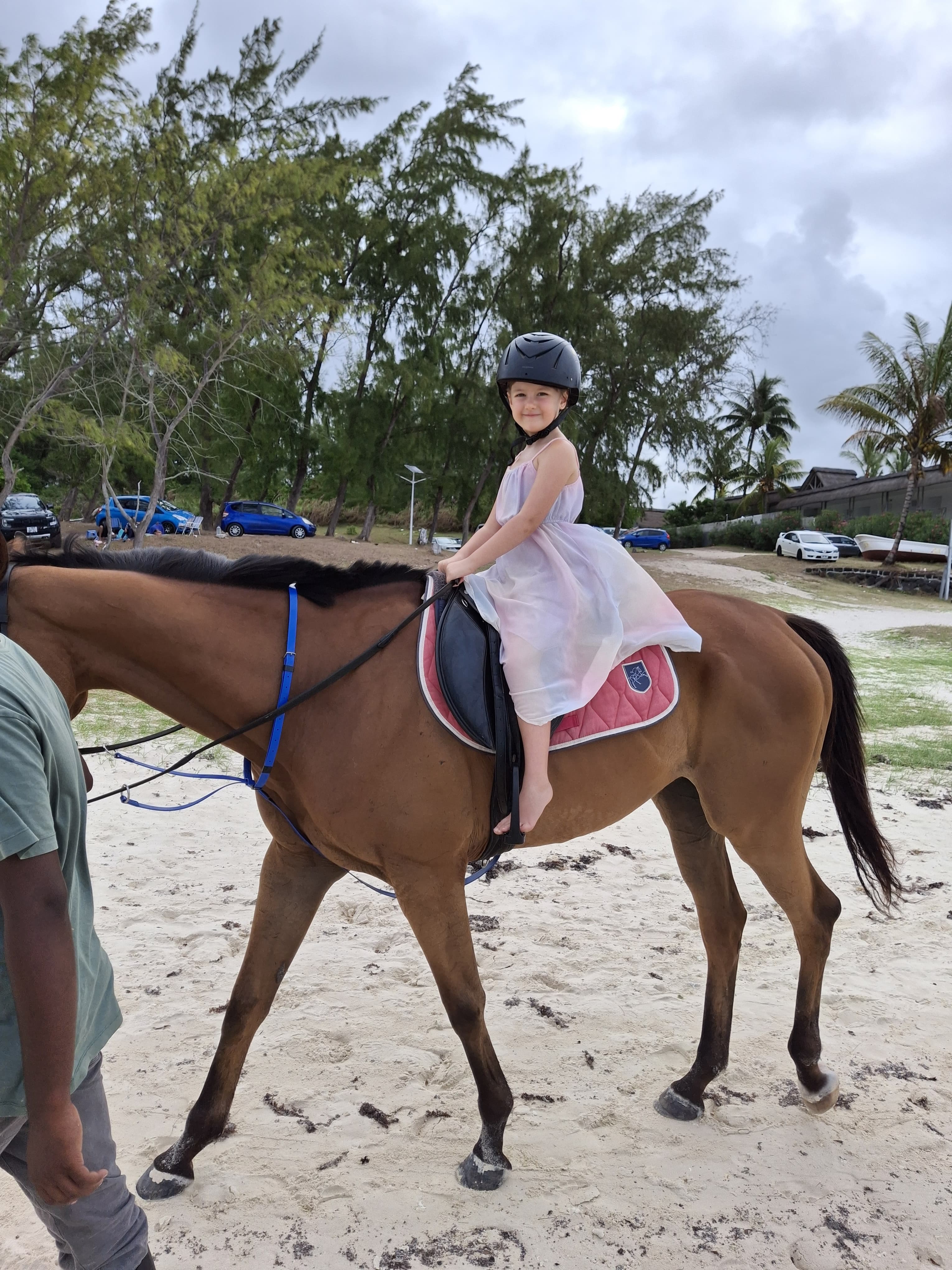A young rider smiling on horseback during a beach ride in Mauritius