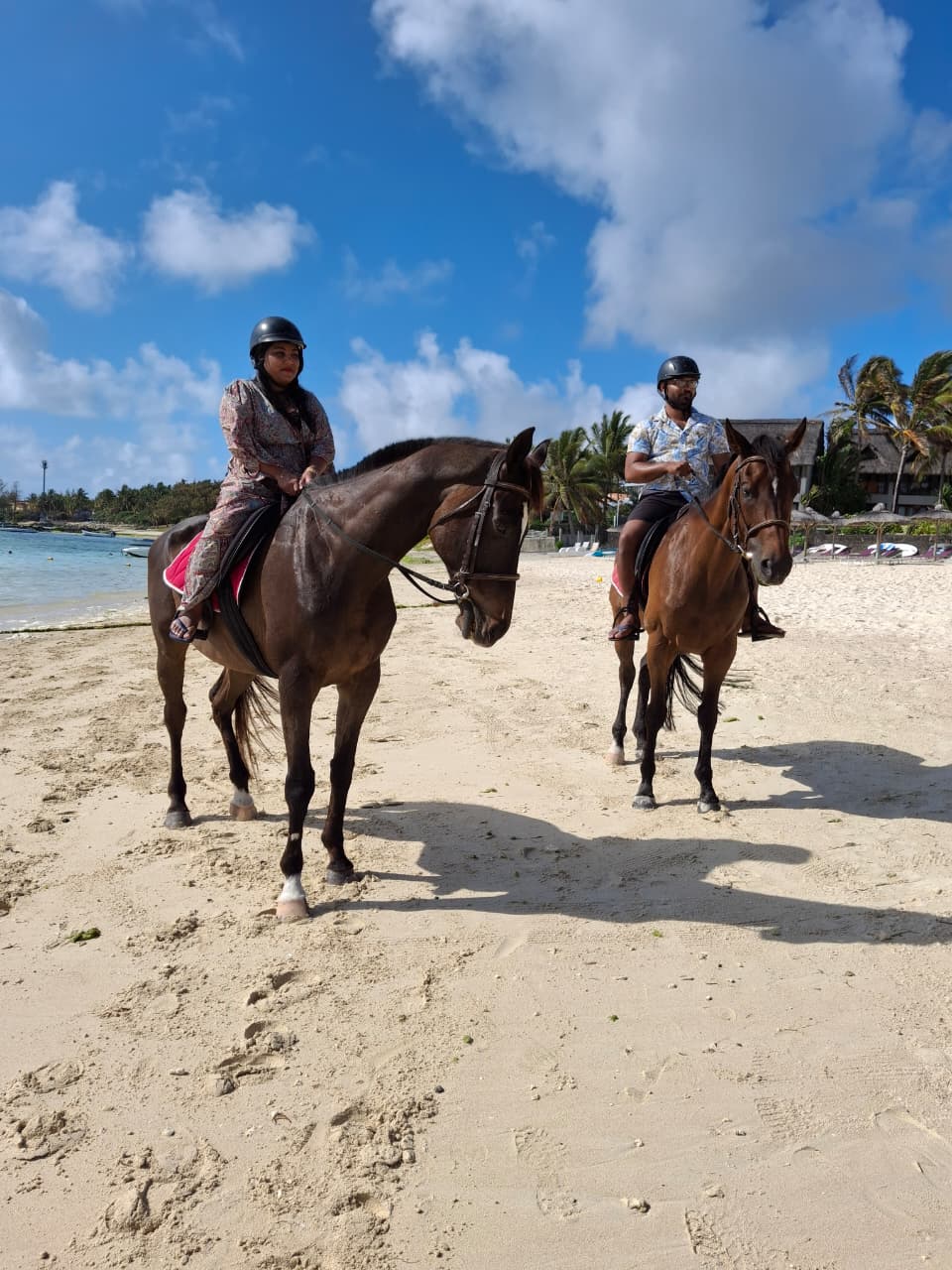 Two riders on horseback sharing a moment on the beach in Mauritius